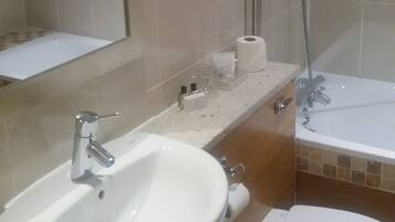 A bathroom with a sink, toilet, and shower.