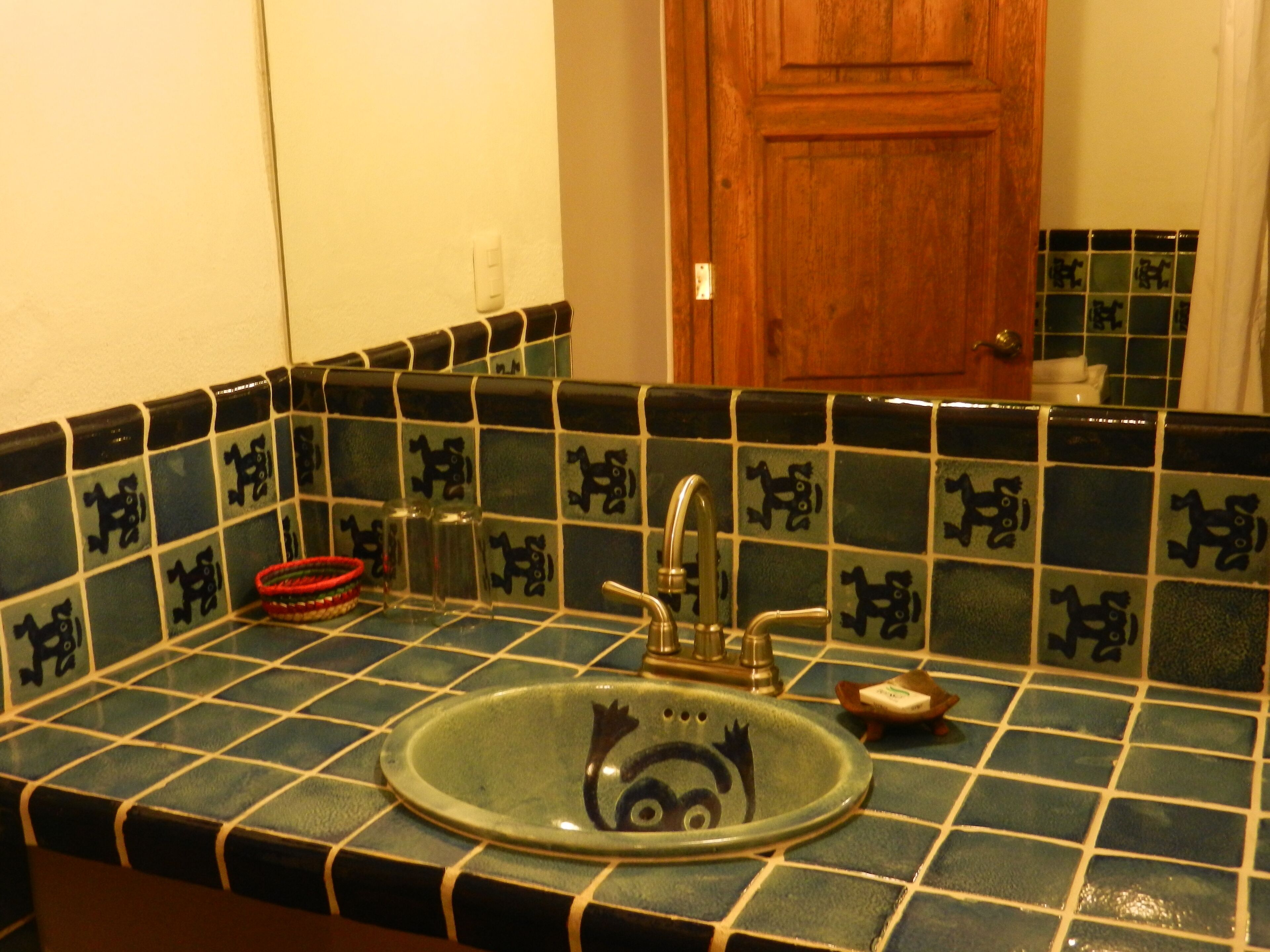A bathroom with a sink, mirror, and tiled backsplash.