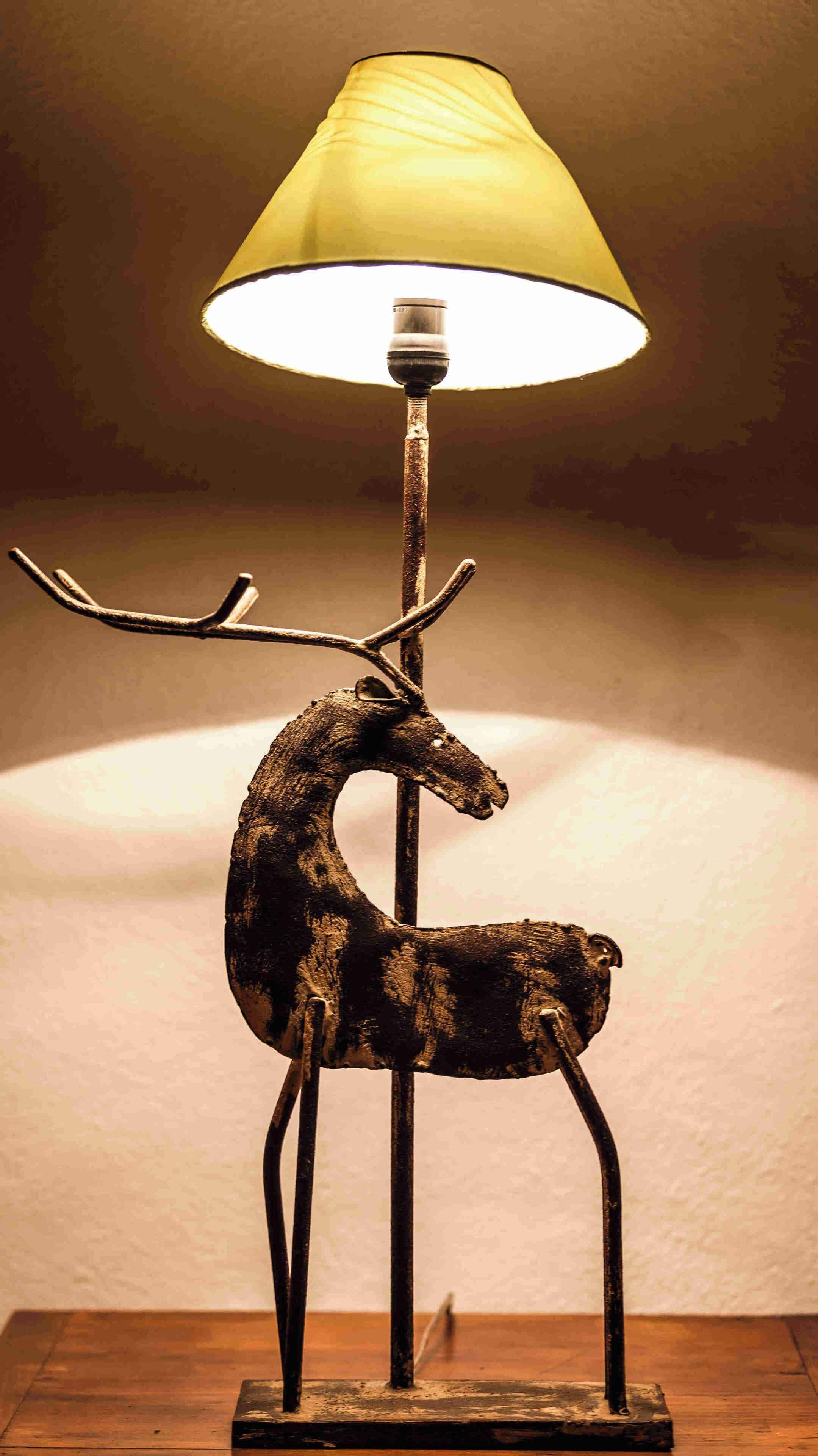 Eine Lampe mit einer Hirschgeweih-Basis und einem gelben Lampenschirm.