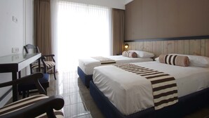 Une chambre d’hôtel avec deux lits, un bureau et une chaise.