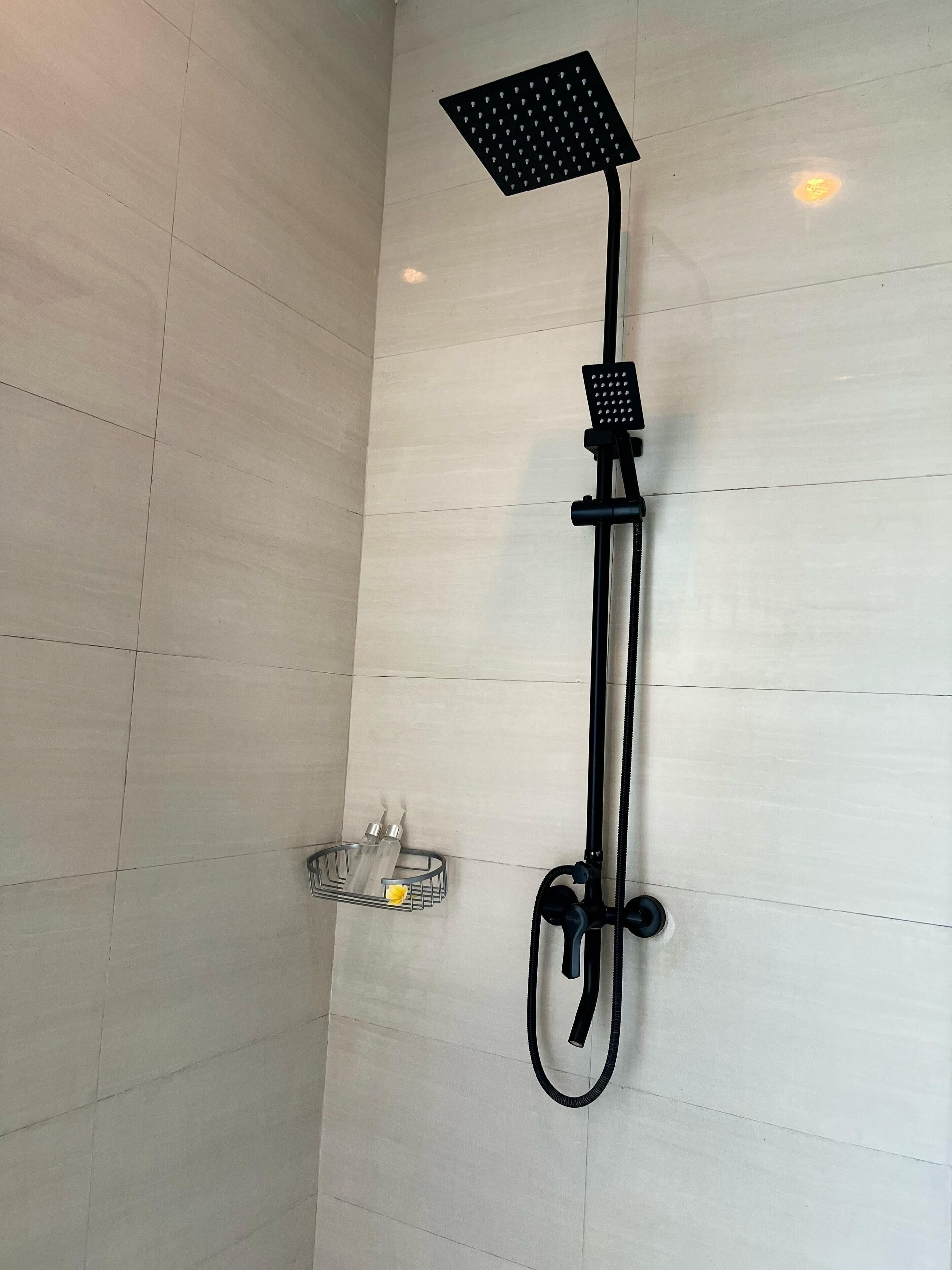 A shower with a square head, a handheld showerhead, and a hose.