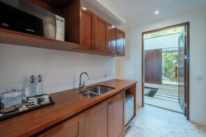 A kitchen with wooden cabinets, a stainless steel sink, and a countertop with kitchenware.