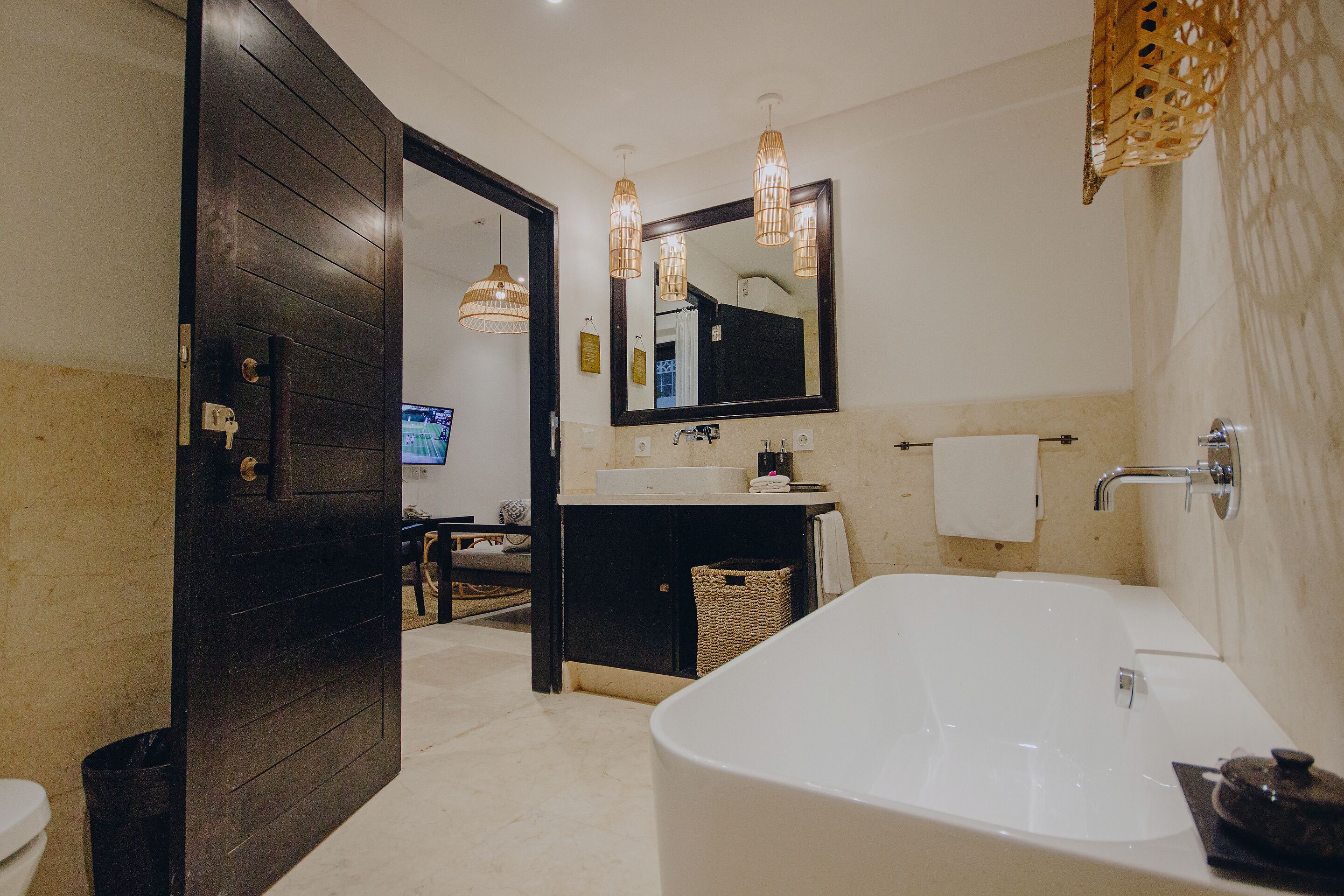 A modern bathroom with a large bathtub, a sink, and a mirror.