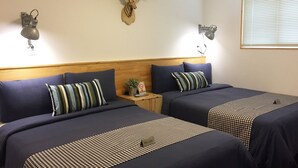 A hotel room with two beds, dark blue bedding, a checkered bedspread, a mounted deer head on the wall, and a 'No Smoking' sign. - Hostel Beige 2nd (Seoul)