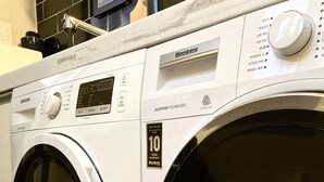 A front-loading washing machine with a digital display and multiple control buttons. - Hostel Beige 2nd (Seoul)