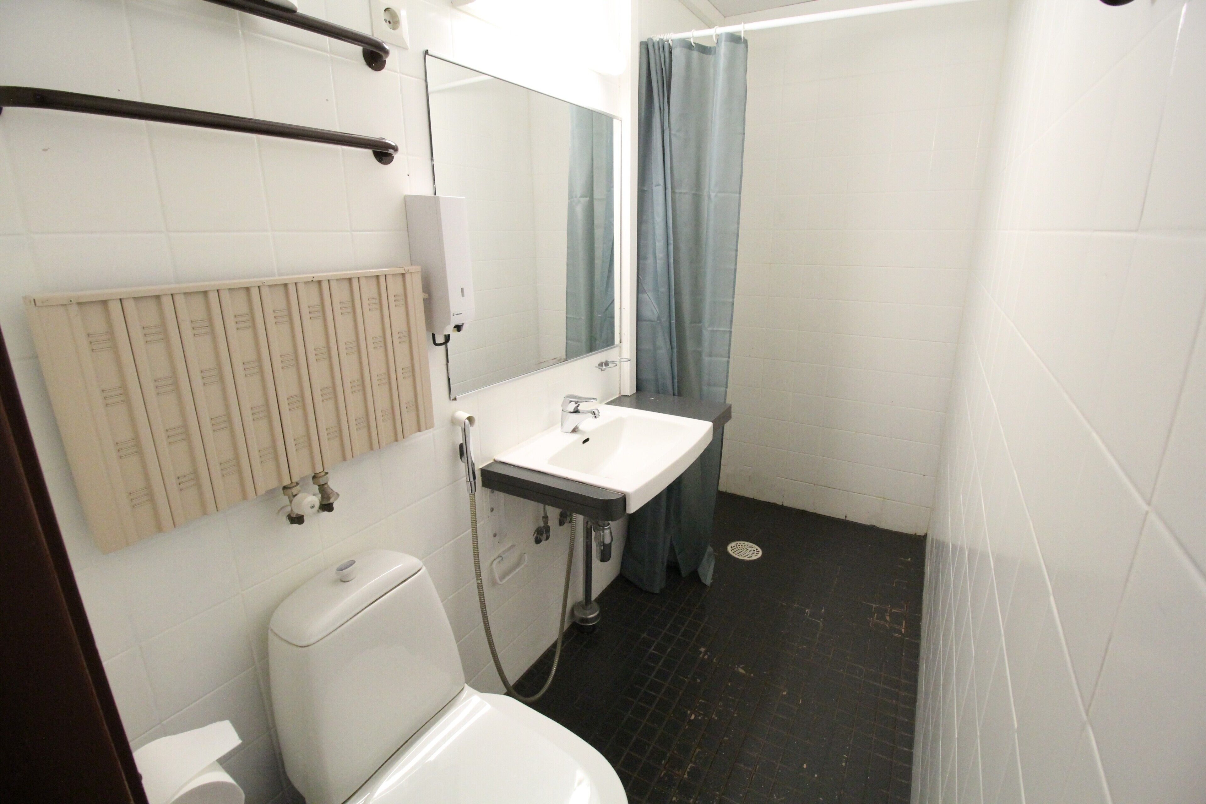 A bathroom with a toilet, sink, and shower.