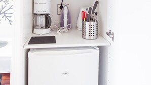 Eine kompakte Küchenzeile mit Mikrowelle, Kaffeemaschine und Ablageflächen.