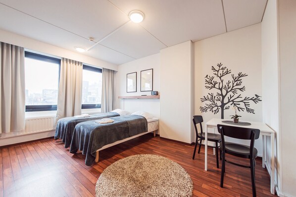 Una habitación de hotel moderna con una cama grande, un escritorio y vistas a la ciudad.