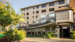 A multi-story building with a flat roof, large windows, and a covered outdoor area with seating. - Park Place Hotel (Nairobi)