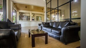 A modern living room with leather sofas, a glass coffee table, and large windows. - Park Place Hotel (Nairobi)