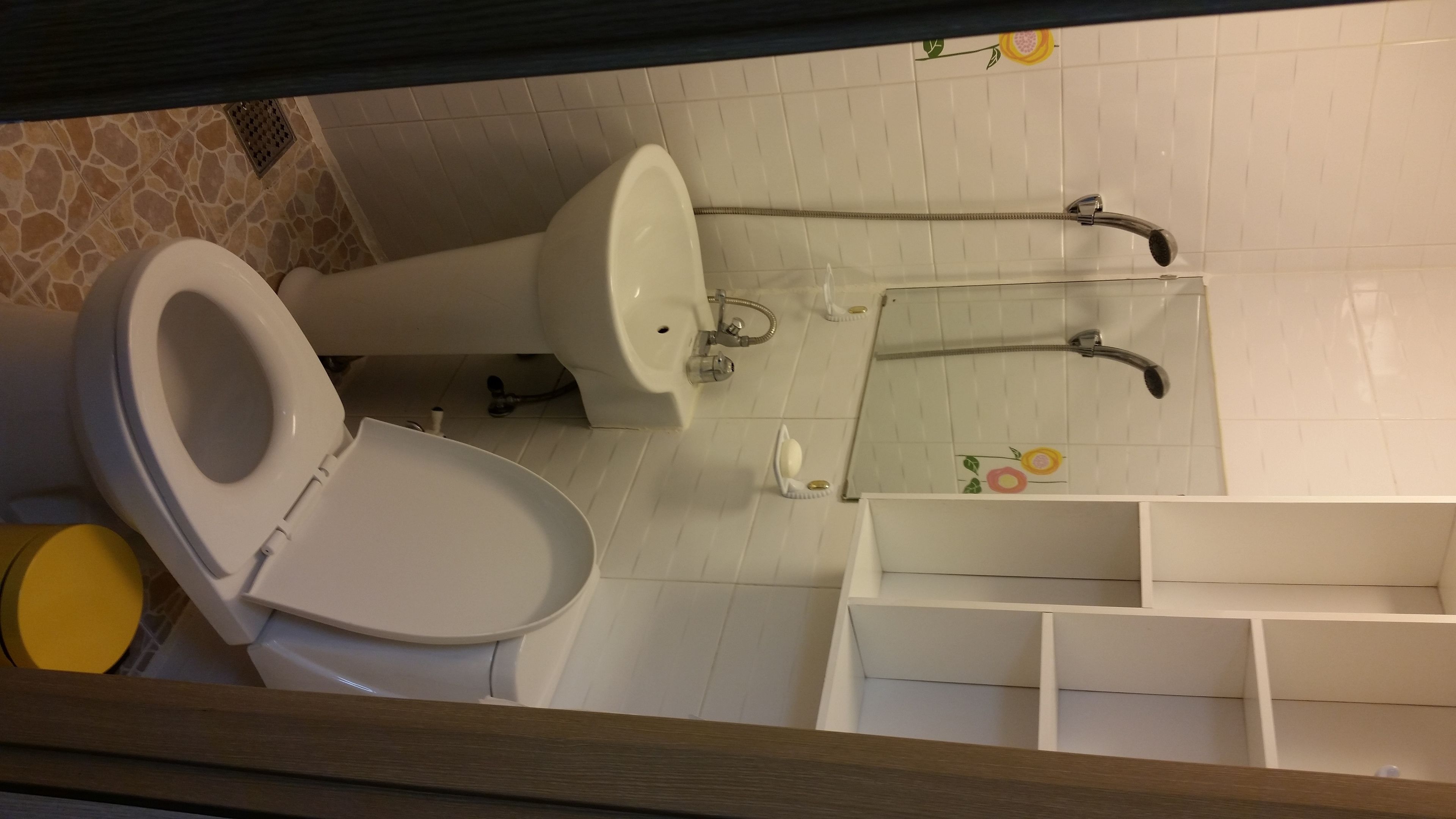 A bathroom with a toilet, sink, and shower.