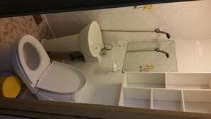 A bathroom with a toilet, sink, and shower.