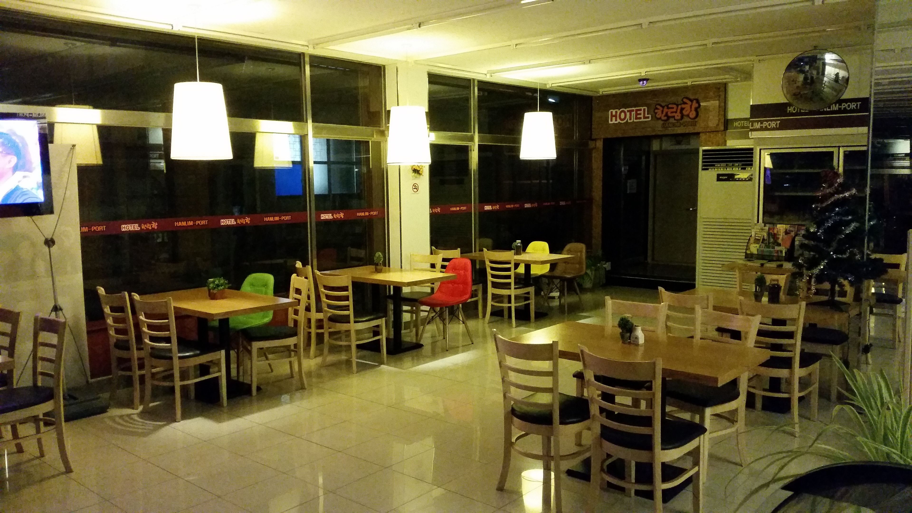 A restaurant with multiple tables and chairs, a TV screen, and a sign indicating it is a hotel.