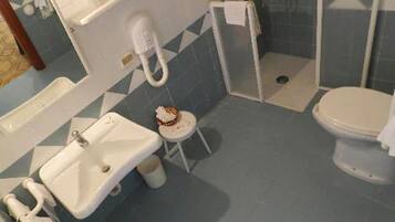 A bathroom with a sink, toilet, and shower area.