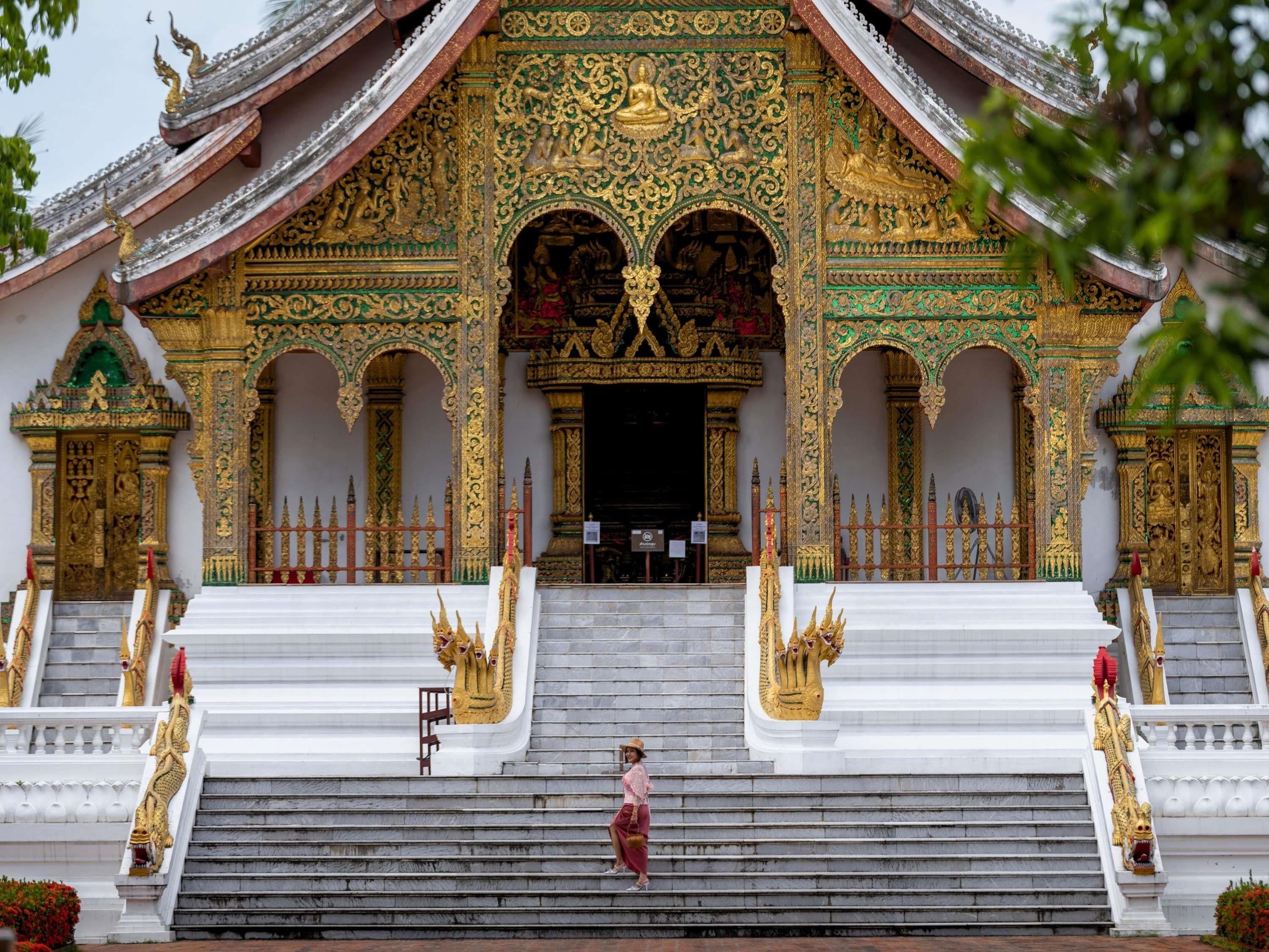 A temple with ornate golden decorations, a central statue, and a staircase leading to the entrance.