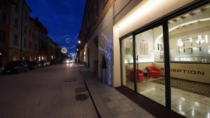 A hotel reception area with a glass facade, a reception desk, and seating. - Albergo Morandi (Reggio nell'Emilia)