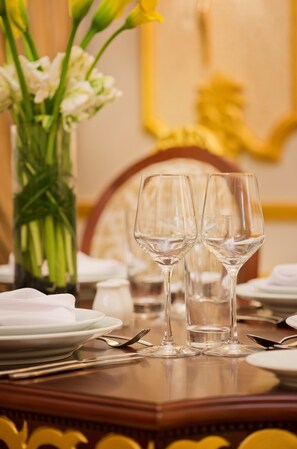 A dining table set with two wine glasses, plates, and cutlery.