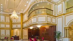Un lobby espacioso con piso de mármol, un mostrador de recepción y muebles elegantes.