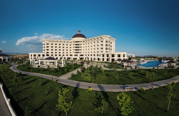 A large, multi-story hotel with a prominent dome and a swimming pool.