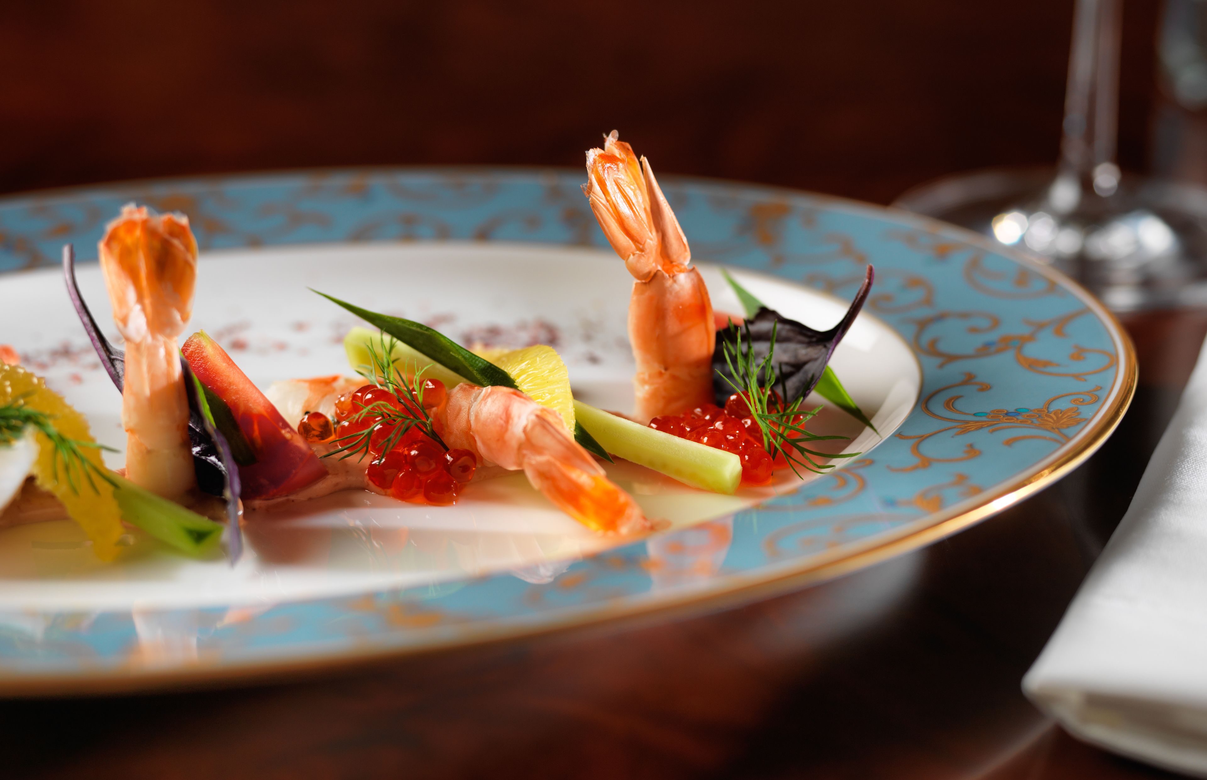 A plate of elegantly arranged seafood appetizers on a decorative plate.