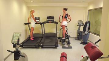 Un gimnasio con cintas de correr, bicicletas estáticas y equipo de ejercicio.