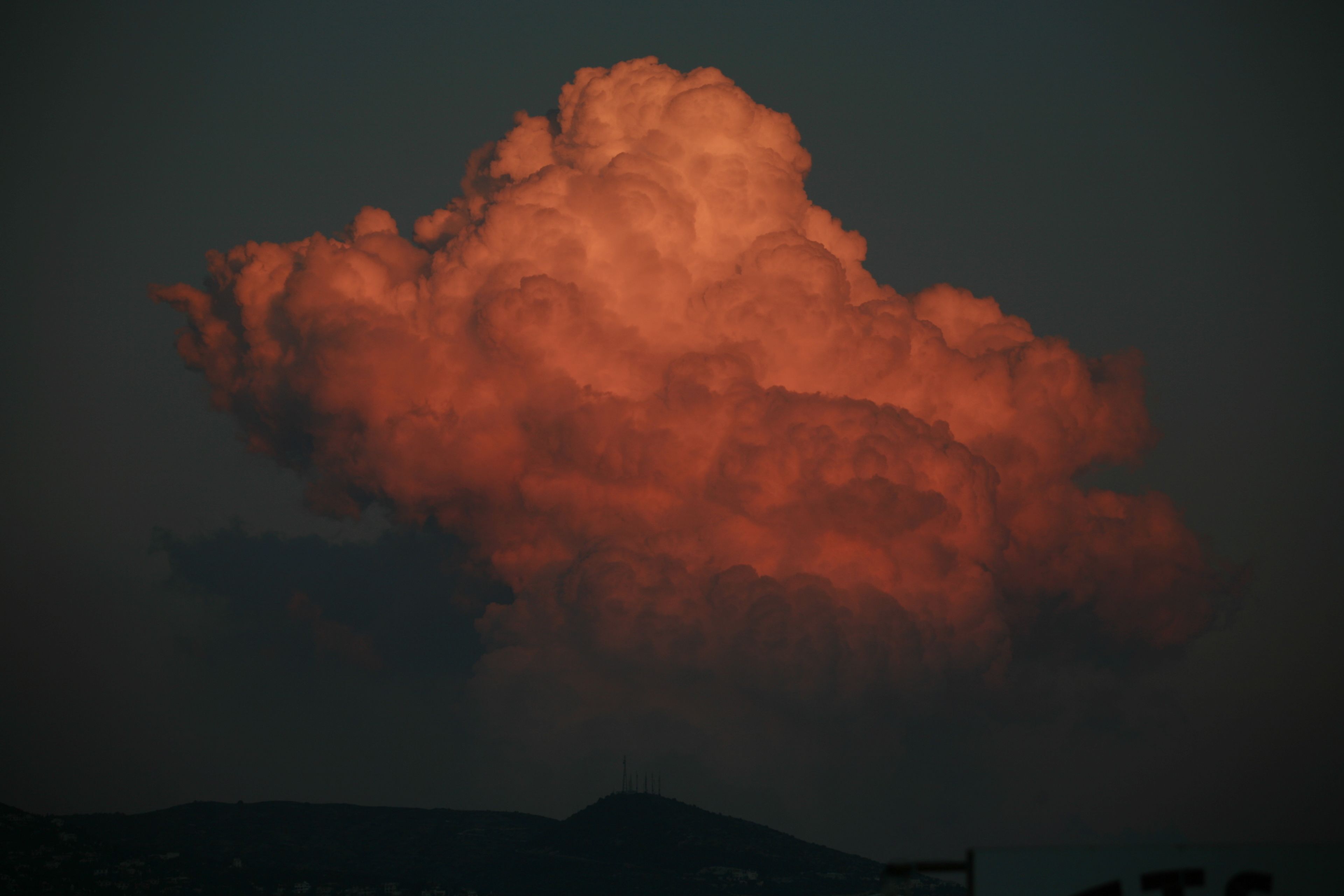 Eine große, flauschige Wolke vor dunklem Himmel.
