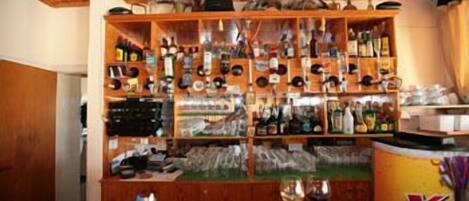 Un espace bar avec des étagères remplies de différentes bouteilles et de verres.