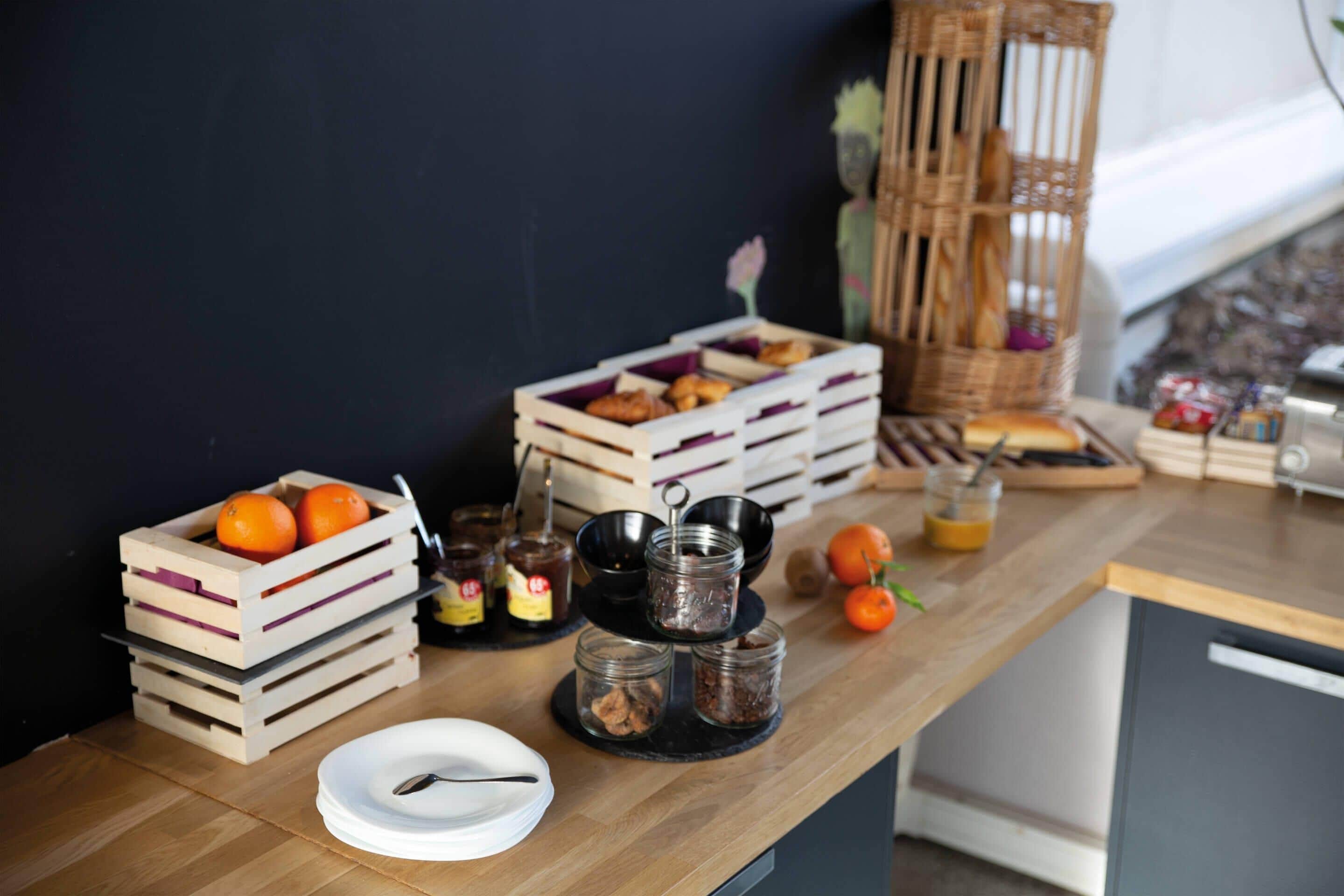 A wooden table with food items, jars, and a basket.