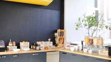 A kitchen counter with various food items, a plant, and kitchen appliances.