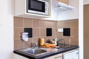 A kitchen with a microwave, sink, and a small refrigerator. - Comfort Aparthotel Antibes Le Maestria (Antibes)