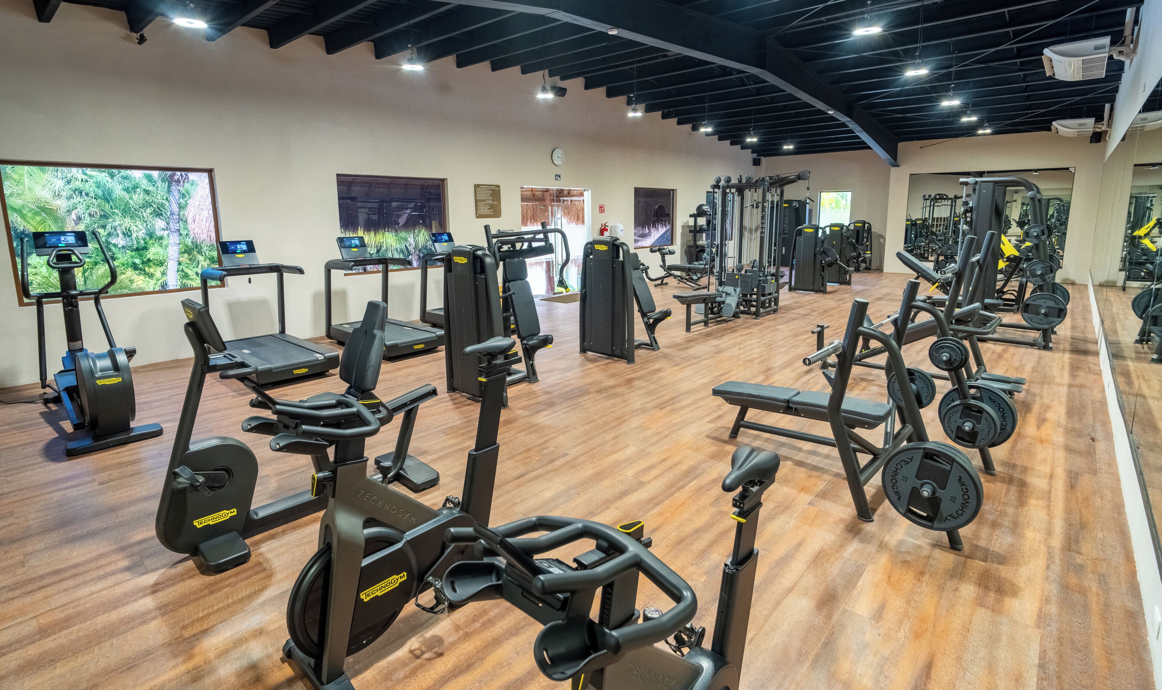Ein Fitnessstudio mit Laufbändern, Crosstrainern und Gewichten.
