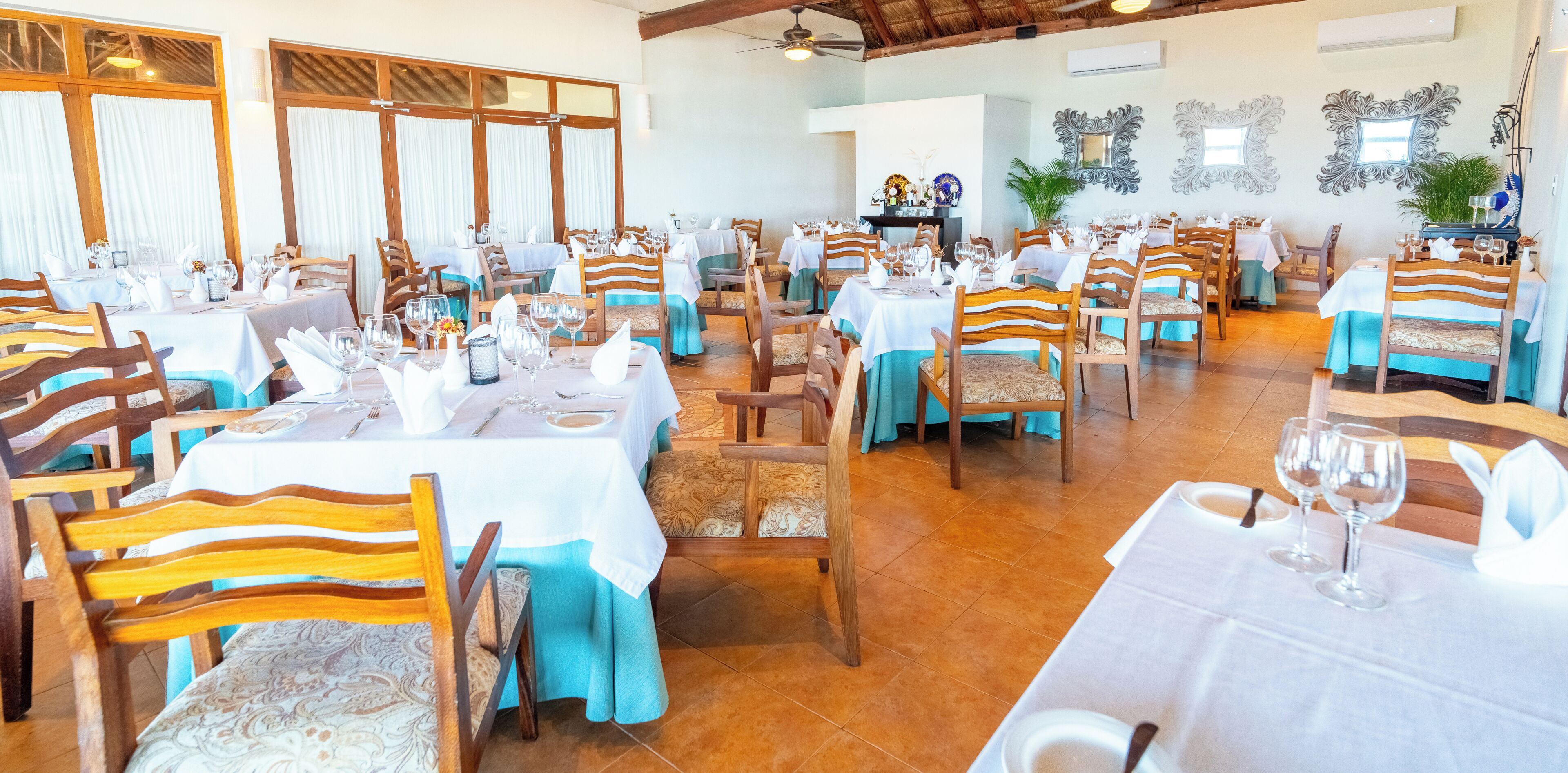 Un restaurant avec plusieurs tables, des chaises et un ventilateur de plafond.