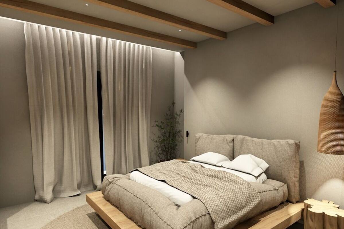 A modern bedroom with a wooden platform bed, neutral-toned bedding, and a hanging light fixture.