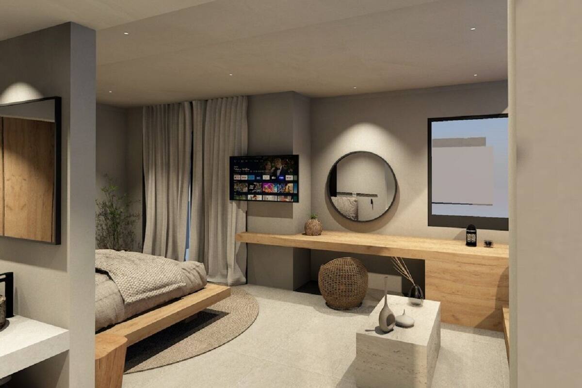 A modern bedroom with a bed, a desk, a TV, and a round mirror.