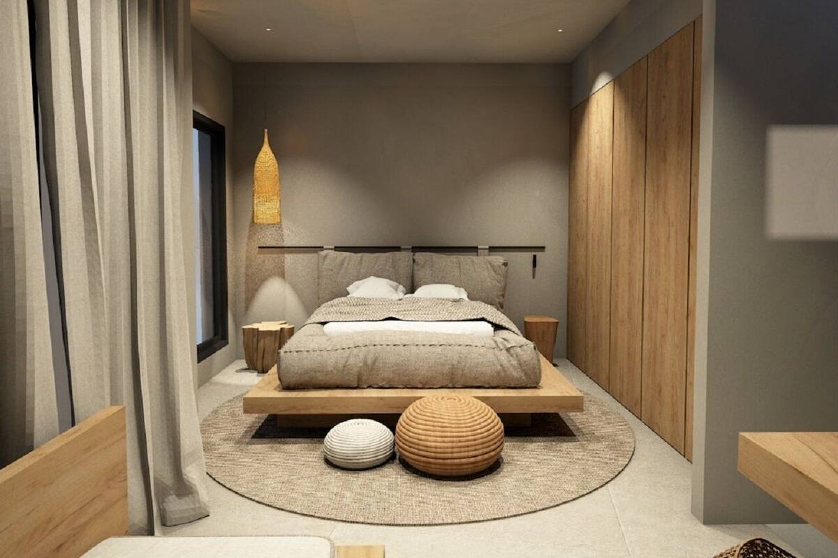 A modern bedroom with a large bed, wooden headboard, and a round rug.