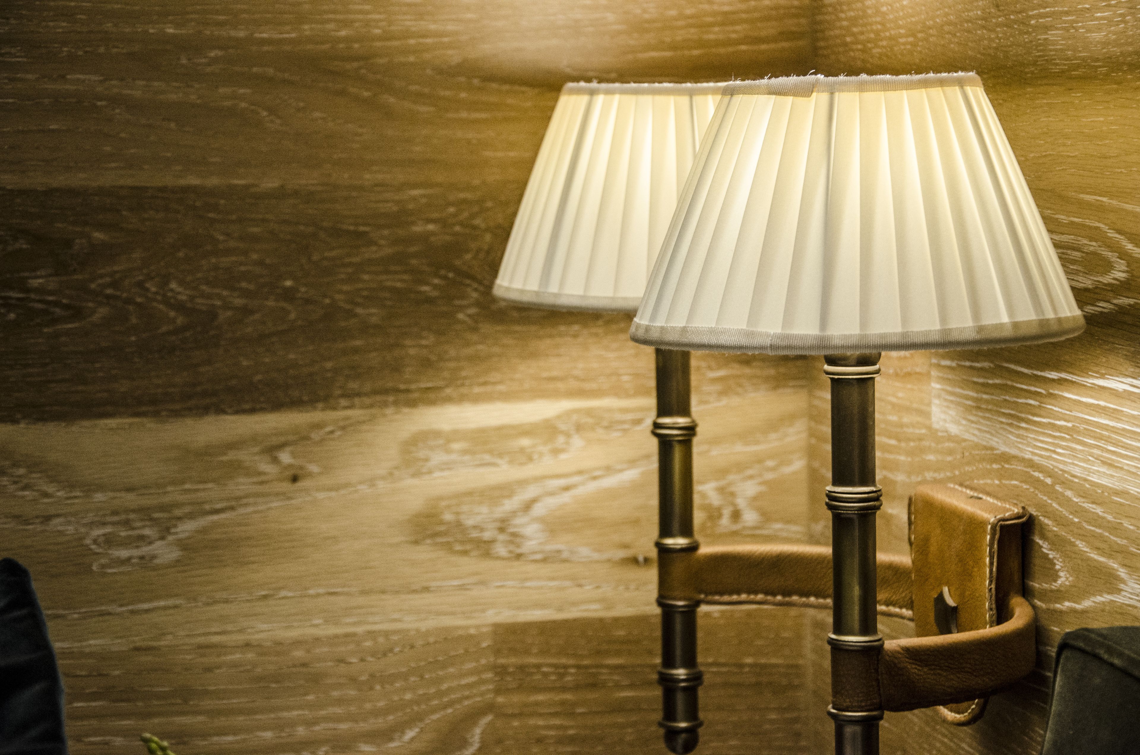 Two lamps with pleated shades on a wooden floor.