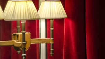Une lampe murale au design classique, dotée de trois abat-jour et d’une finition en laiton.