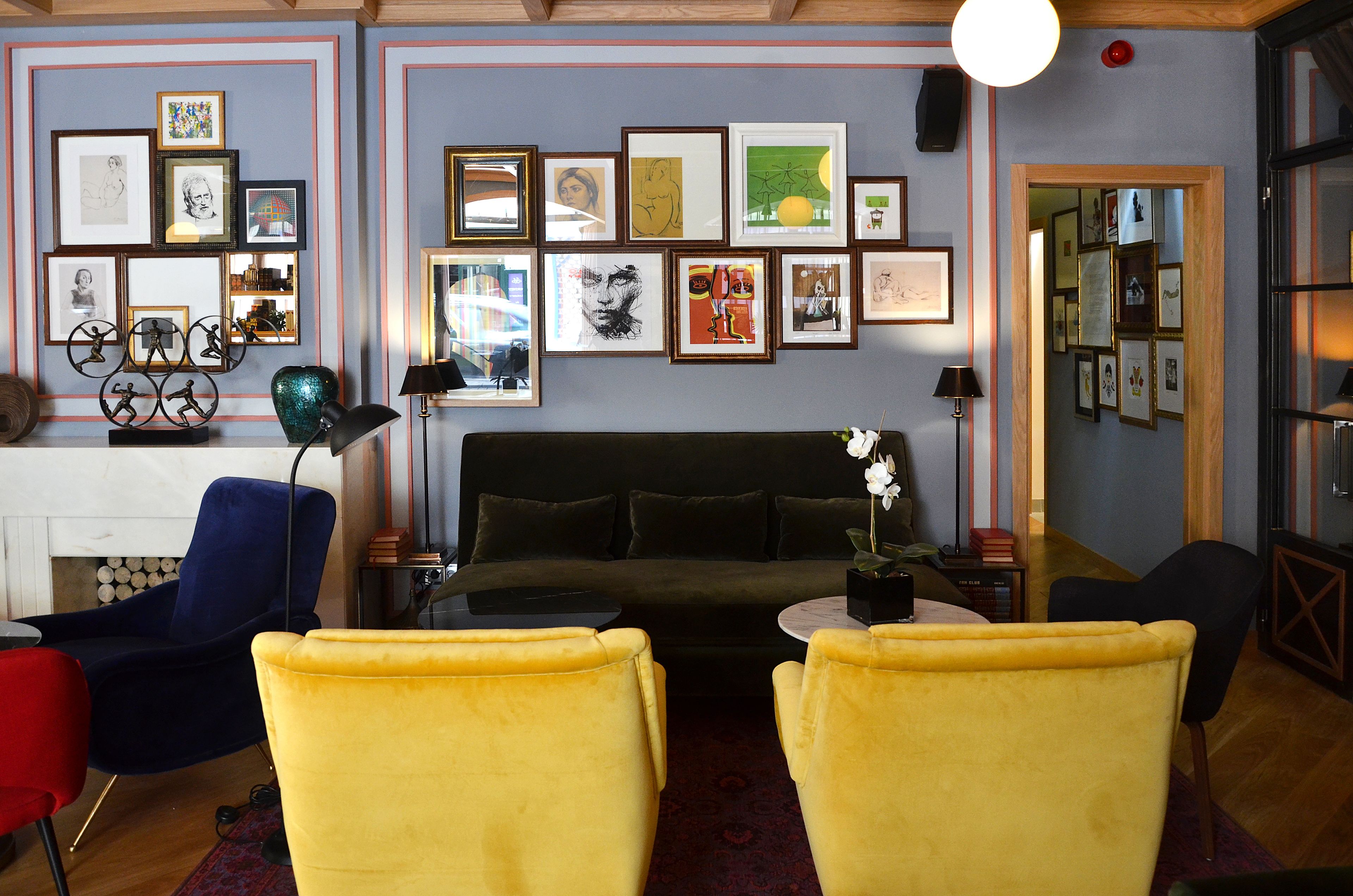 A living room with a sofa, yellow chairs, a coffee table, and a fireplace.