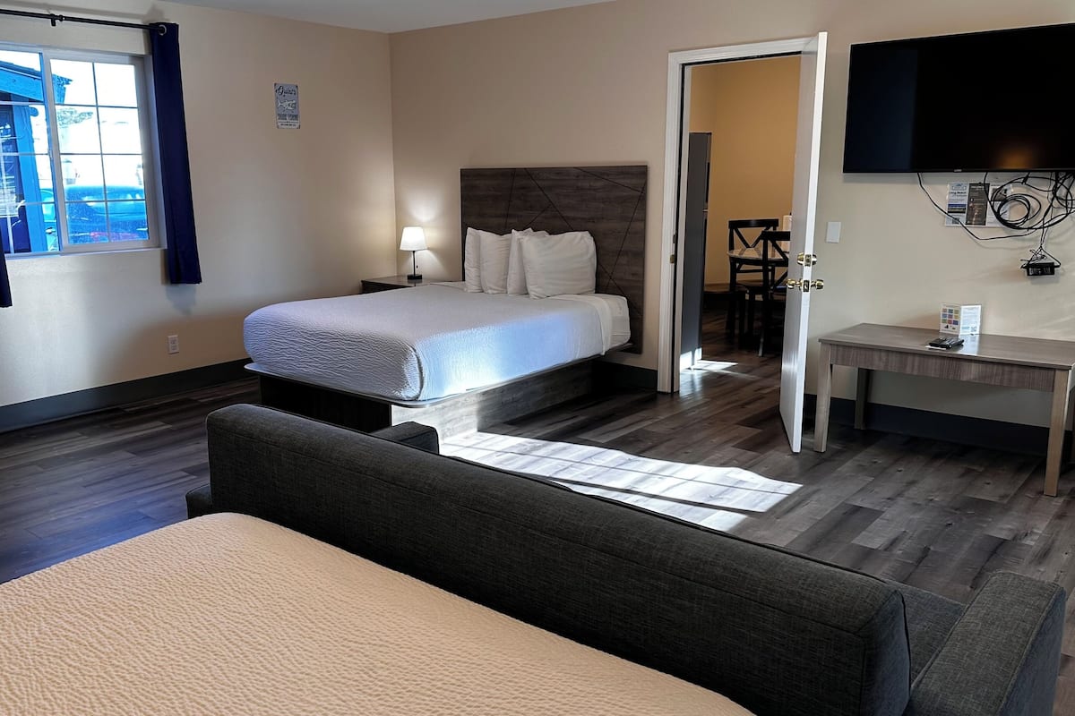 Una habitación de hotel con cama, mesita de noche, lámpara y escritorio con silla.