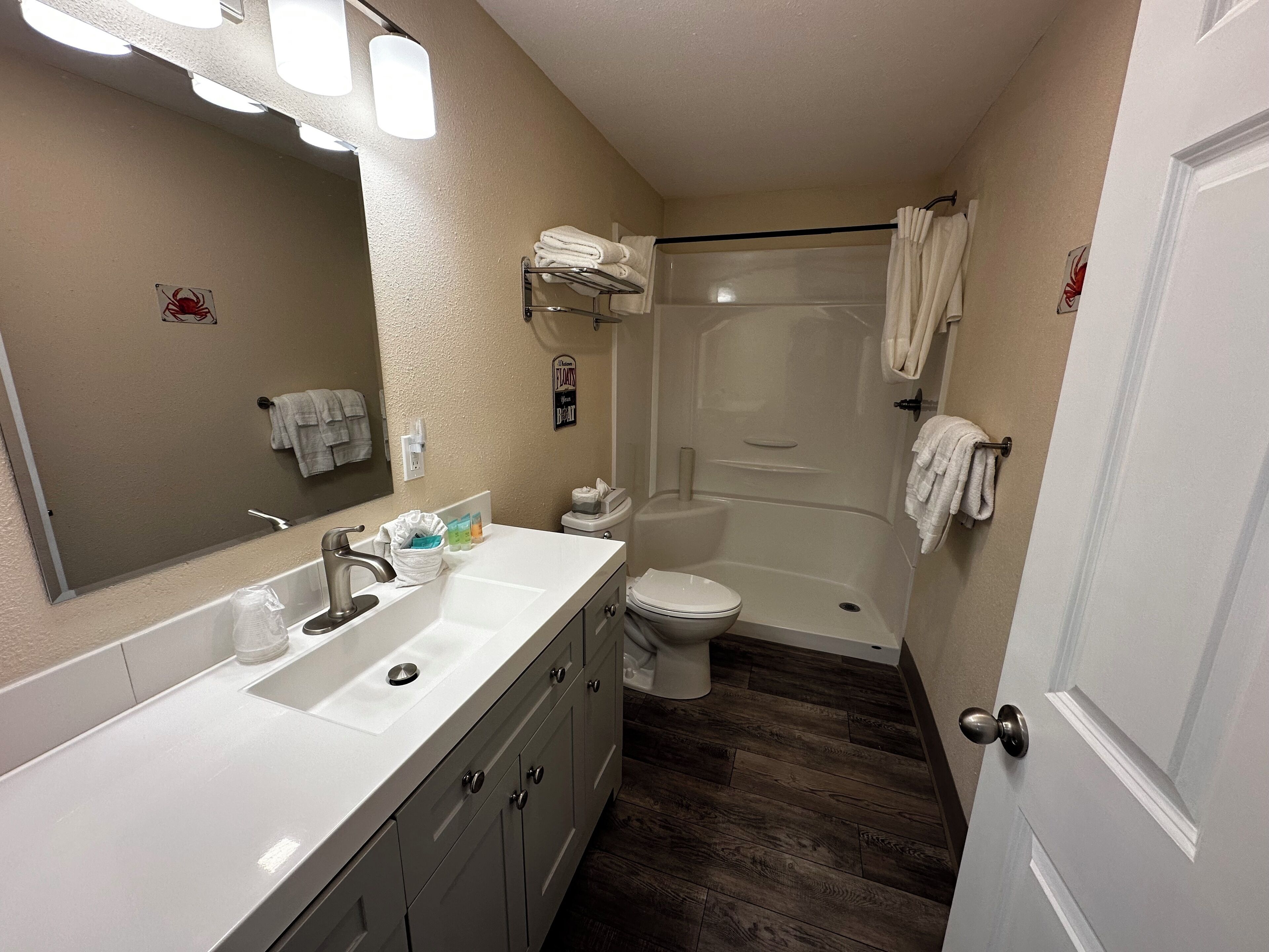 A bathroom with a white sink, a toilet, and a shower area.