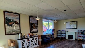 A cozy interior with wooden floors, a fireplace, and a display of canned goods. - The Coastal Inn and Suites (Long Beach)