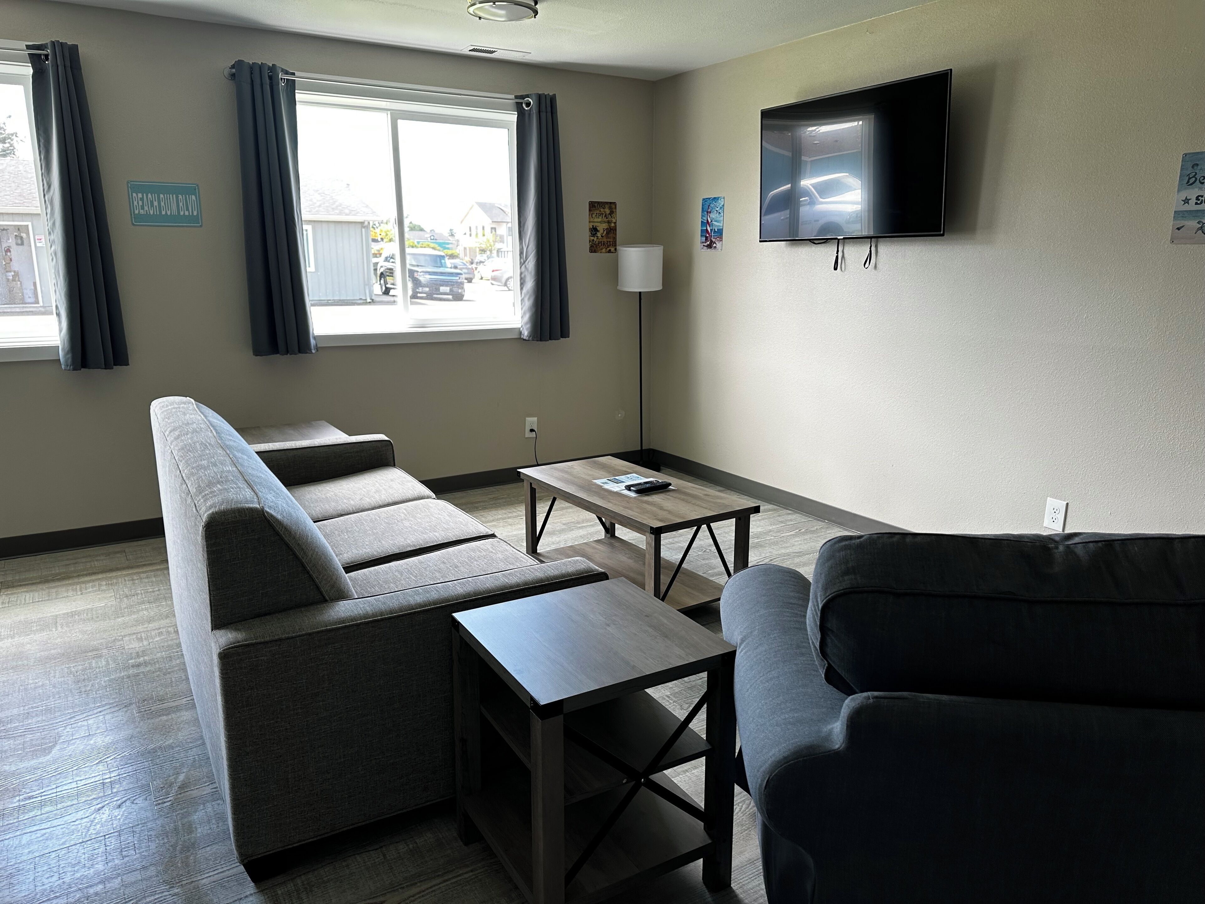 A modern living room with a sofa, a coffee table, and a TV mounted on the wall.