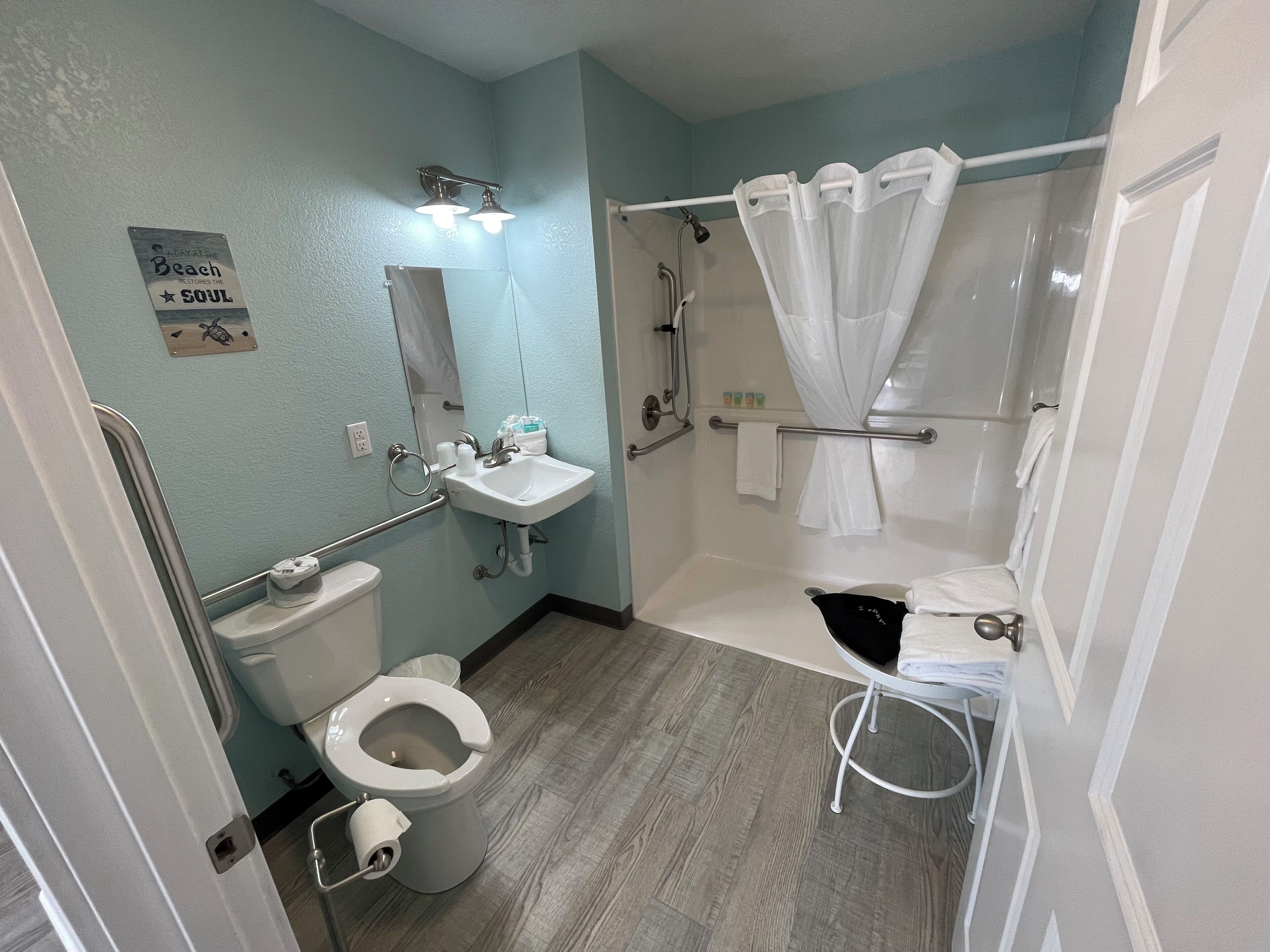 A bathroom with a toilet, sink, and shower area.