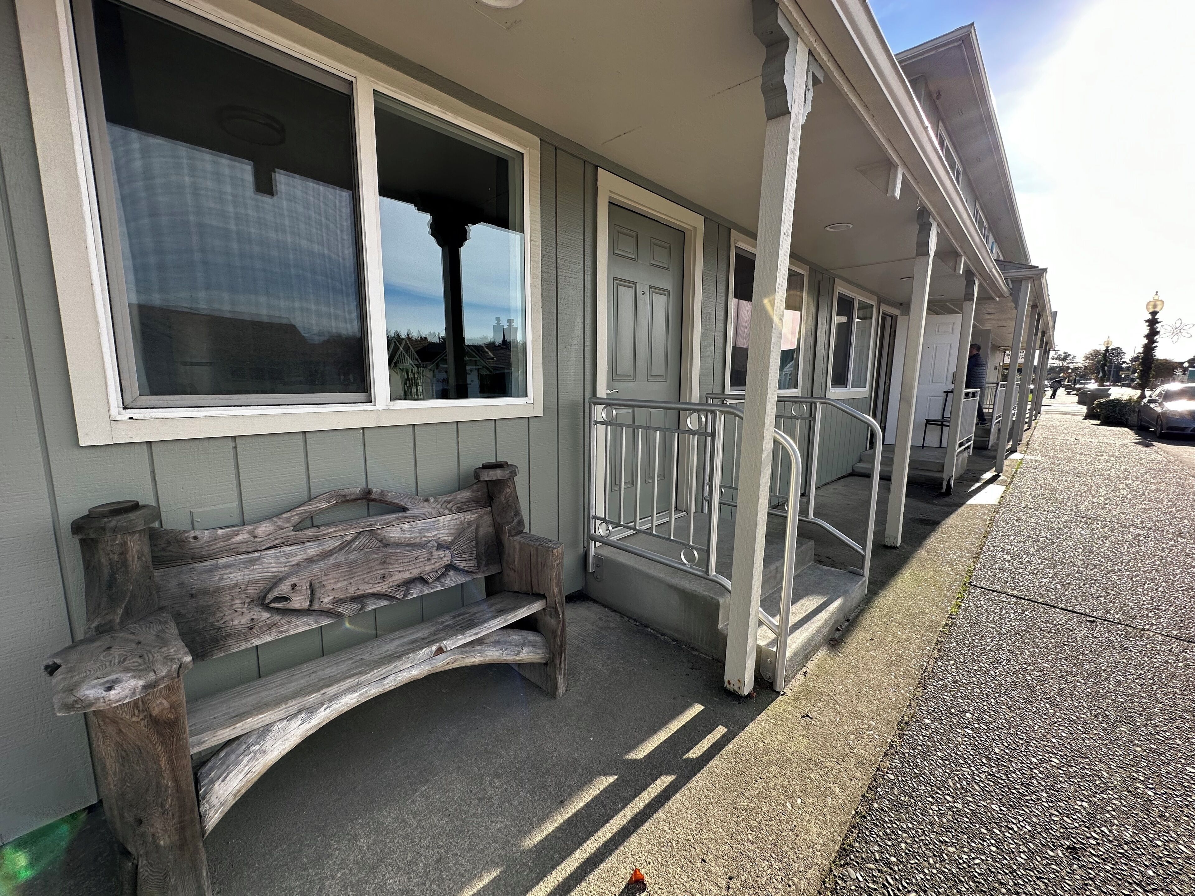 Un bâtiment doté d’un porche, d’un banc et d’un escalier menant à l’entrée.