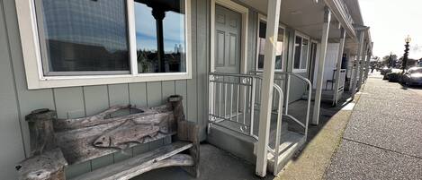 Un bâtiment doté d’un porche, d’un banc et d’un escalier menant à l’entrée.