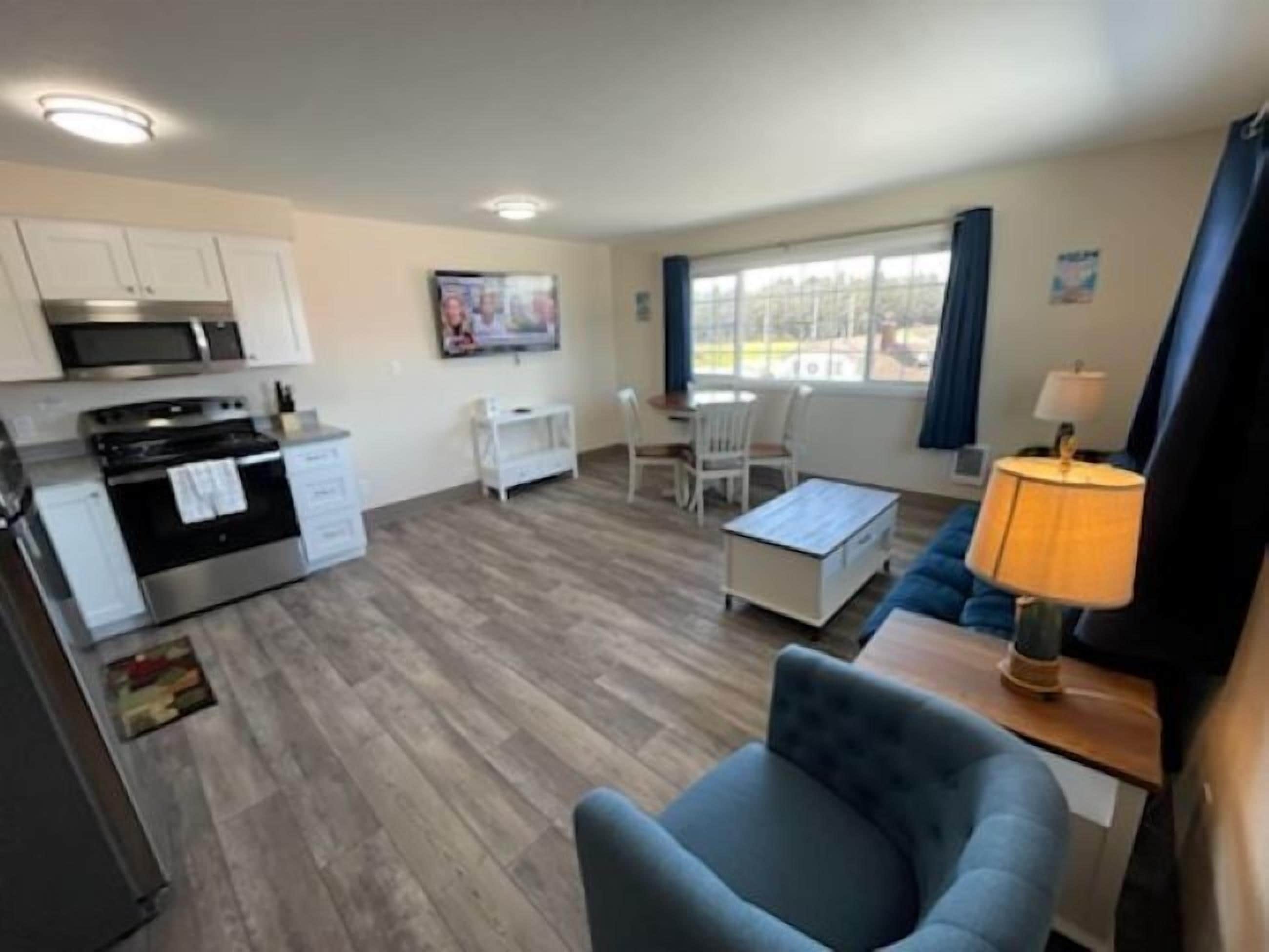A compact living space with a kitchenette, a dining area, and a seating area with a lamp.