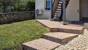 Un edificio de dos pisos con una escalera de madera y una pared de piedra.