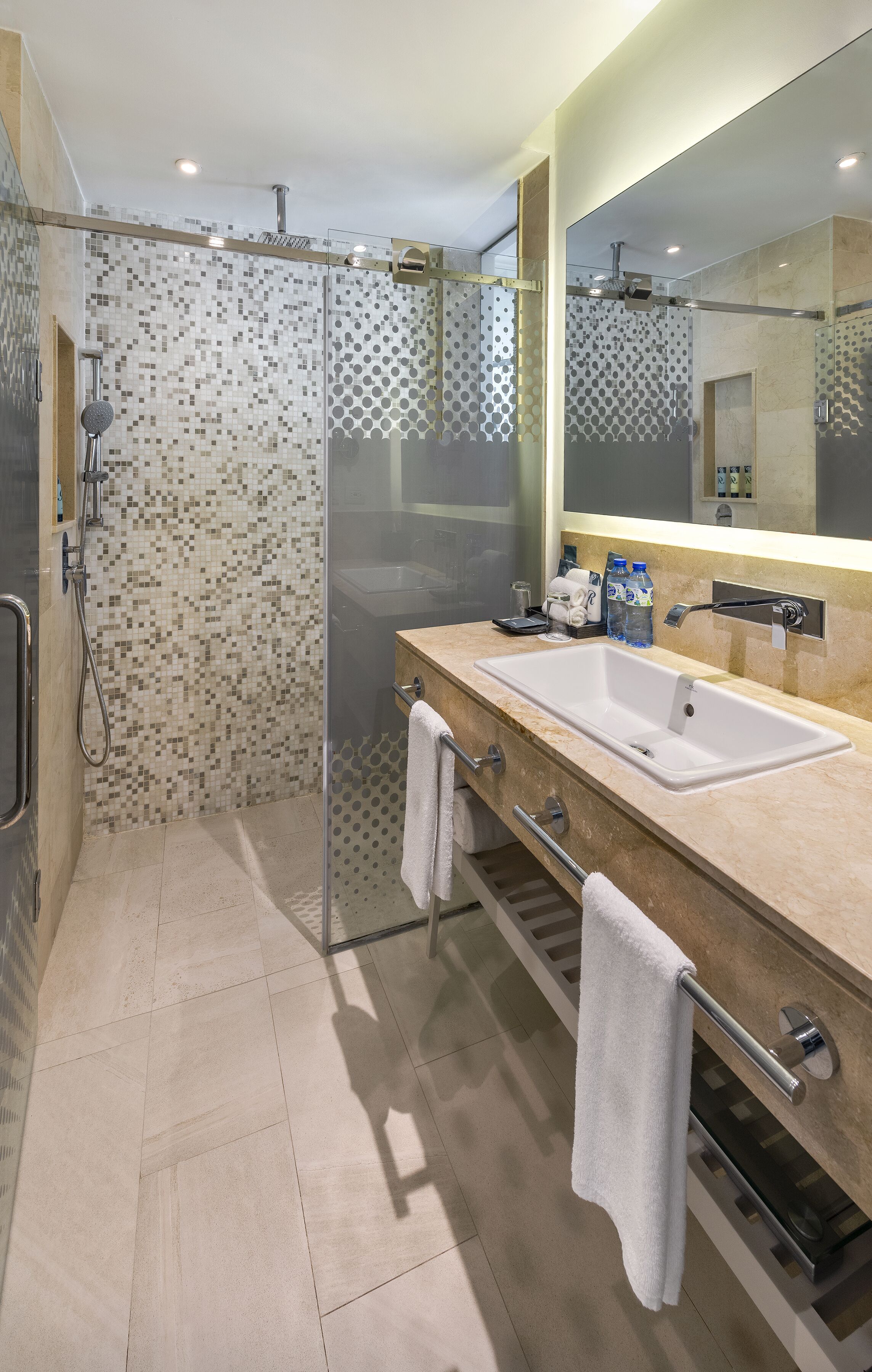 A modern bathroom with a glass-enclosed shower, a double sink vanity, and a large mirror.