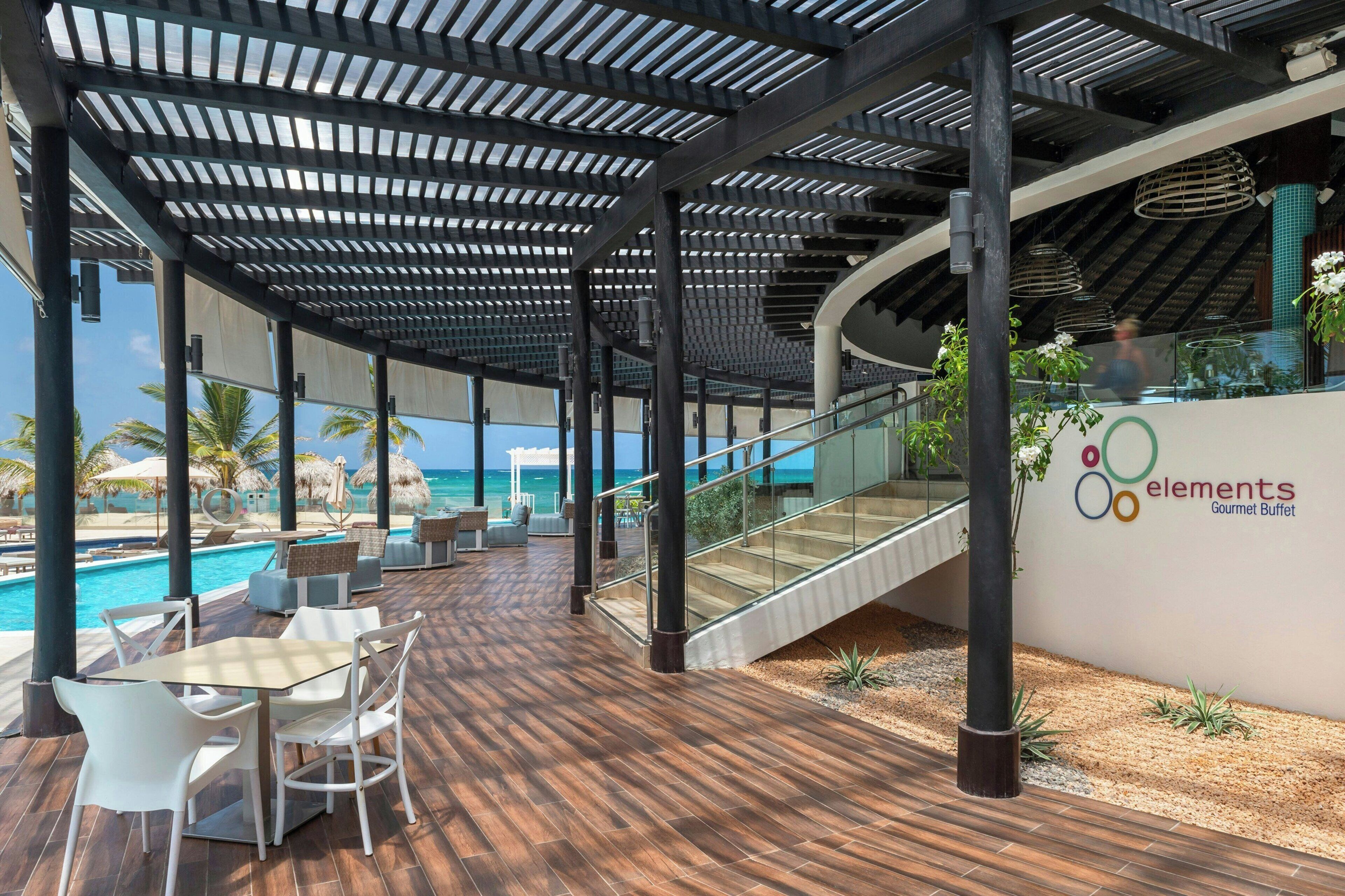 Un espace extérieur abrité comprenant une piscine, des sièges et un escalier menant à un niveau supérieur.