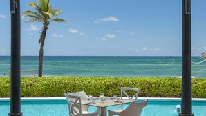 A covered outdoor seating area with a pool and ocean view. - Royalton CHIC Punta Cana, An Autograph Collection All-Inclusive Resort & Casino – Adults Only (Punta Cana)